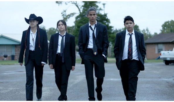 Four teenagers in suits walking down a road, from the series Reservation Dogs