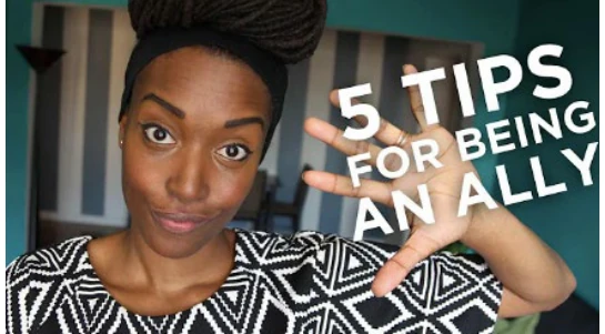 Chescaleigh holding up a sign reading 5 Tips For Being An Ally