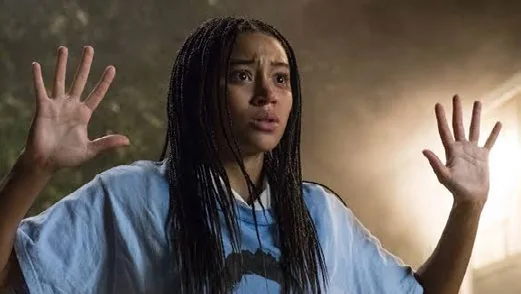 Starr Carter standing with her hands raised, from the film The Hate U Give